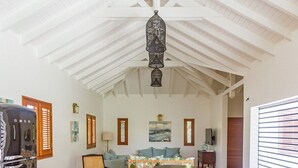 Cucina spaziosa con isola centrale ampia, mobili in legno e lampadario a sospensione.