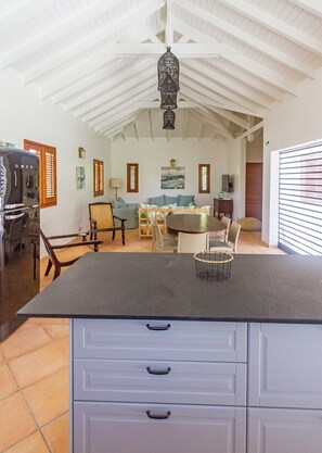 Una cocina amplia con una isla grande, armarios de madera y una lámpara colgante.