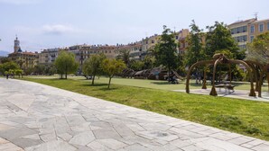 A paved walkway with a stone pattern, surrounded by greenery and trees. - Old Nice- Jean Jaurès FSHH (NICE)