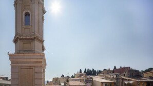 A tall, classical tower with a clock, surrounded by traditional buildings with tiled roofs. - Old Nice- Jean Jaurès FSHH (NICE)