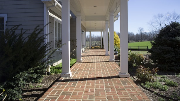A covered porch with brick flooring and white columns, leading to a green field. - Quiet, Spacious House Close to SML and Liberty University (Moneta)