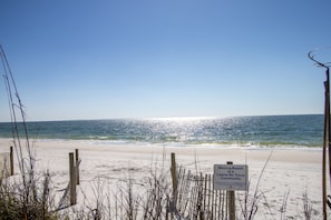 Una playa con un cartel que dice "Mexico Beach es una comunidad que no deja rastro".
