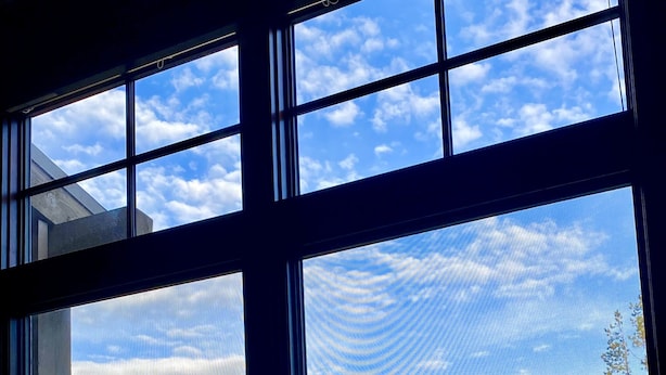A view through a window with a clear sky and a forested area with a building in the background. - 0.5 mile walk to Gondola and Keystone Village!  50 yards to Keystone Shuttle!   (Keystone)
