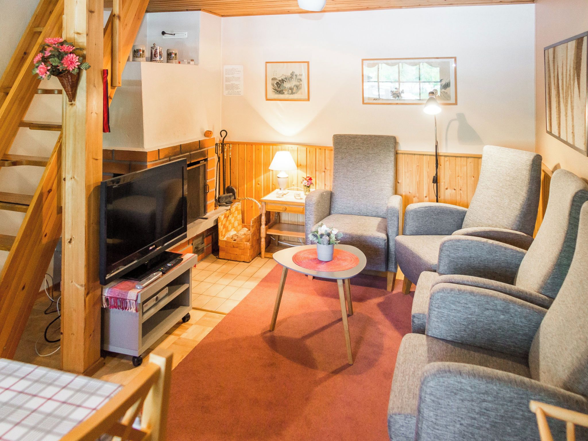Ein gemütliches Wohnzimmer mit Fernseher, Kamin und bequemen Sitzmöglichkeiten.