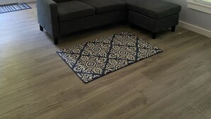 Una sala moderna con un sofá modular, un tapete estampado y un espejo grande en la pared.