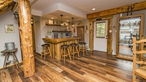 Ein rustikales Interieur mit einer Holztheke, Hockstühlen und einer großen Holzsäule.