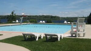 Ein Schwimmbecken mit Liegestühlen und einem Rettungsschwimmerstand.