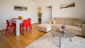 A modern living room with a dining area, a beige sofa, and a coffee table.
