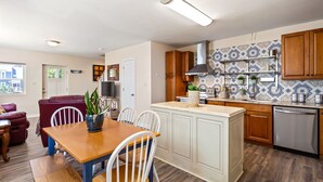 Una cocina moderna con armarios de madera, una isla integrada y un salpicadero de azulejos.