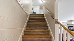 Una escalera con escalones de madera y paredes blancas.