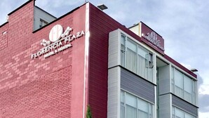 A hotel named 'Florencia Plaza' with a red brick facade and a modern glass building. - Hotel Florencia Plaza (Medellín)