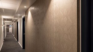 A long, narrow hallway with a patterned wall and carpeted floor. - Quest 256 Lambton (Wellington)