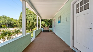A covered porch with a bench and a door. - Adorable Chesapeake Bay Beach Cottage B Just 1 Block from the Sand! (Virginia Beach)