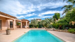 A rectangular swimming pool with a clear blue water surface, surrounded by a paved patio area with potted plants and a pergola structure. - Villa for 8 people, 16 minutes' walk from the beaches and town center of Ste Maxime (SAINTE MAXIME)