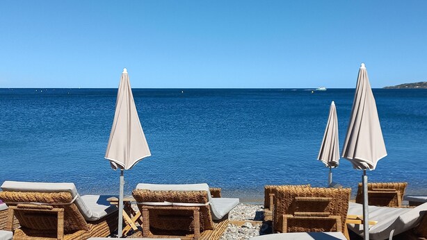 A beachside lounge with wicker chairs and umbrellas, overlooking a calm sea with distant boats. - Villa for 8 people, 16 minutes' walk from the beaches and town center of Ste Maxime (SAINTE MAXIME)