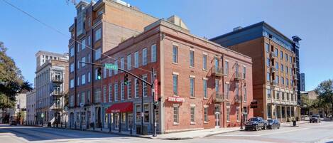 A multi-story building with a ground-floor retail space, including a Five Guys restaurant.