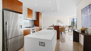 Una cocina moderna con electrodomésticos de acero inoxidable, armarios de madera y una isla central.