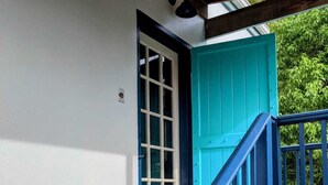 Una escalera con barandillas azules que lleva a una puerta turquesa.