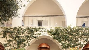A building with a covered entrance, steps leading up to it, and potted plants on either side. - Hotel Terme Oriente Beach & SPA (Ischia)
