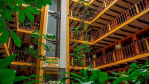 A multi-level atrium with balconies, bookshelves, and hanging plants. - Catedral Hotel (San Cristóbal de las Casas)