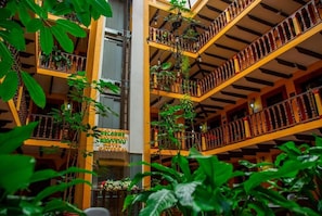 A multi-level atrium with balconies, bookshelves, and hanging plants.