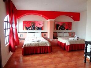 A hotel room with two beds, red curtains, and artwork on the walls. - Catedral Hotel (San Cristóbal de las Casas)