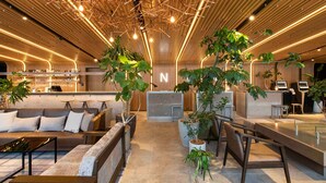 Un interior moderno con techo de madera, zonas de estar y un bar.