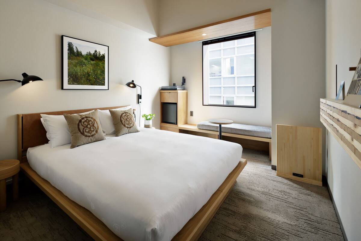 Un dormitorio moderno con una cama grande, un escritorio y una ventana.