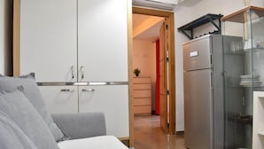 Una cocina compacta con refrigerador, lavamanos y encimera.