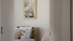 A bedroom with a bed, pillows, and a framed picture on the wall. - Nikatara - Mission Beach (Mission Beach)