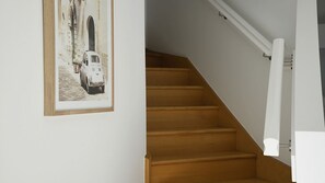 A staircase with wooden steps and a white handrail.