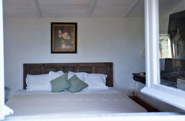 Cozy retreat with a single bed and a framed painting above.