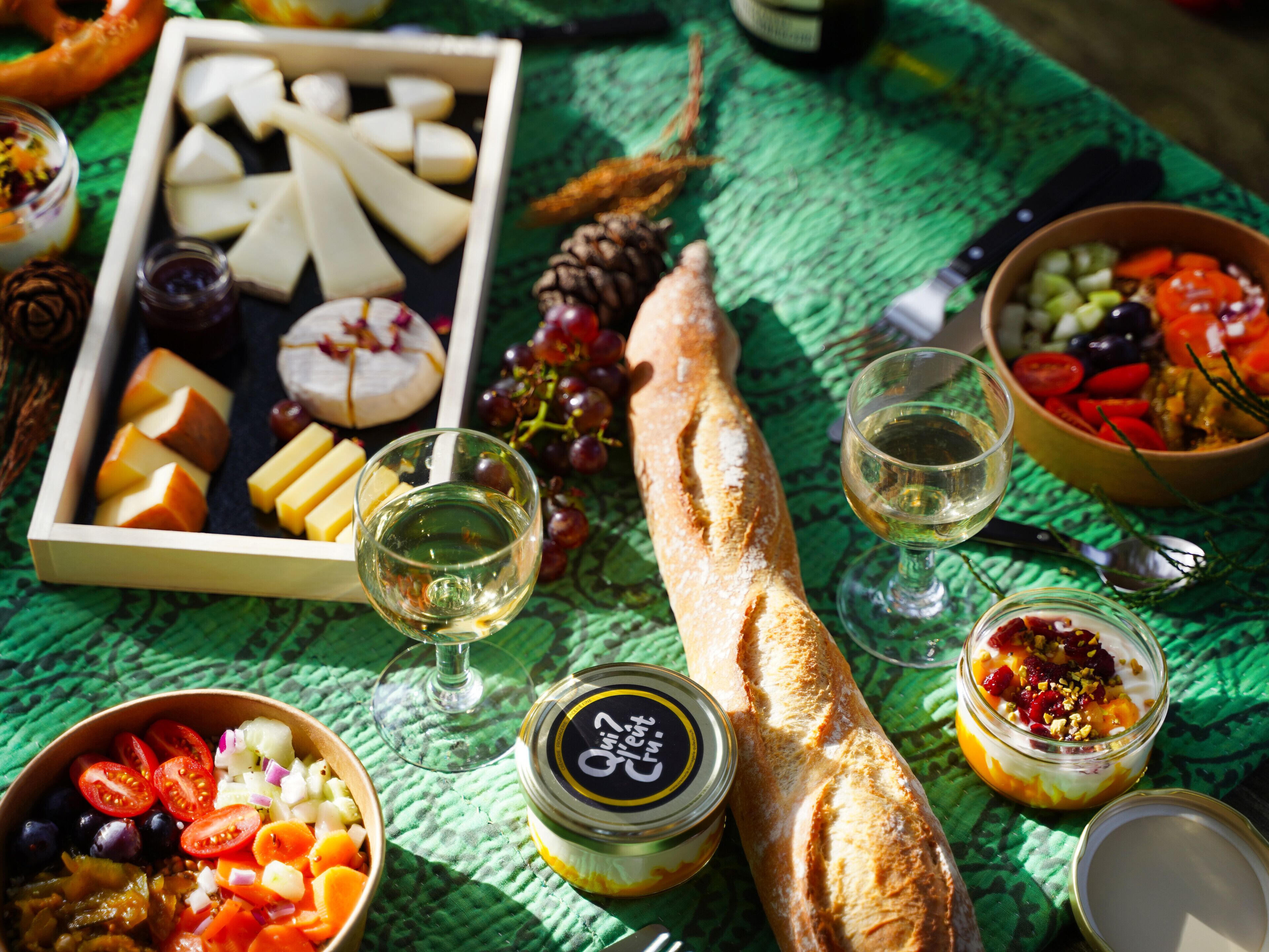A table with various food items including cheese, bread, and a jar of pickles.