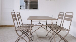 A room with a white door, a window, and a table with four chairs. - OYO 789 Abn Residences (Bacolod)