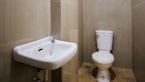 A bathroom with a white sink, a toilet, and a mirror on the wall. - OYO 789 Abn Residences (Bacolod)