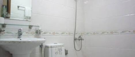 A bathroom with a sink, toilet, and shower.