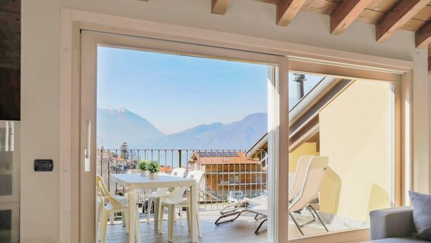 A room with a sliding glass door leading to a balcony with a mountain view.