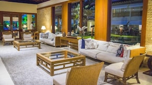 A spacious living area with a large sofa, two armchairs, and a coffee table. There are large windows with a view of greenery outside. - Jatiuca Hotel and Resort (Maceió)