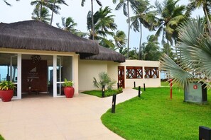 A resort with a thatched-roof building, palm trees, and a well-maintained lawn. - Jatiuca Hotel and Resort (Maceió)