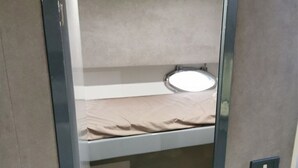A bunk bed with a small round mirror above it. - Boating Oliday (Castellammare di Stabia)