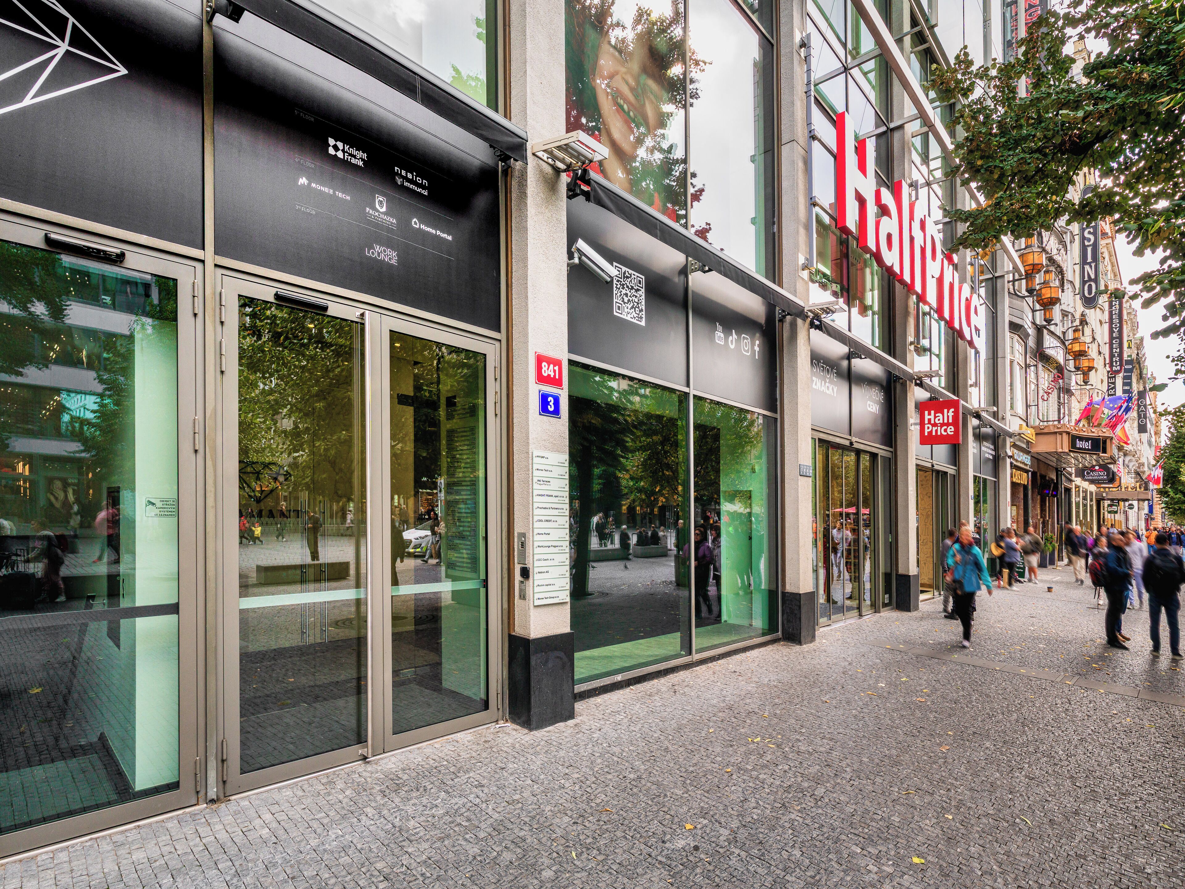 A hotel with a prominent red sign, large glass windows, and a QR code on the door.