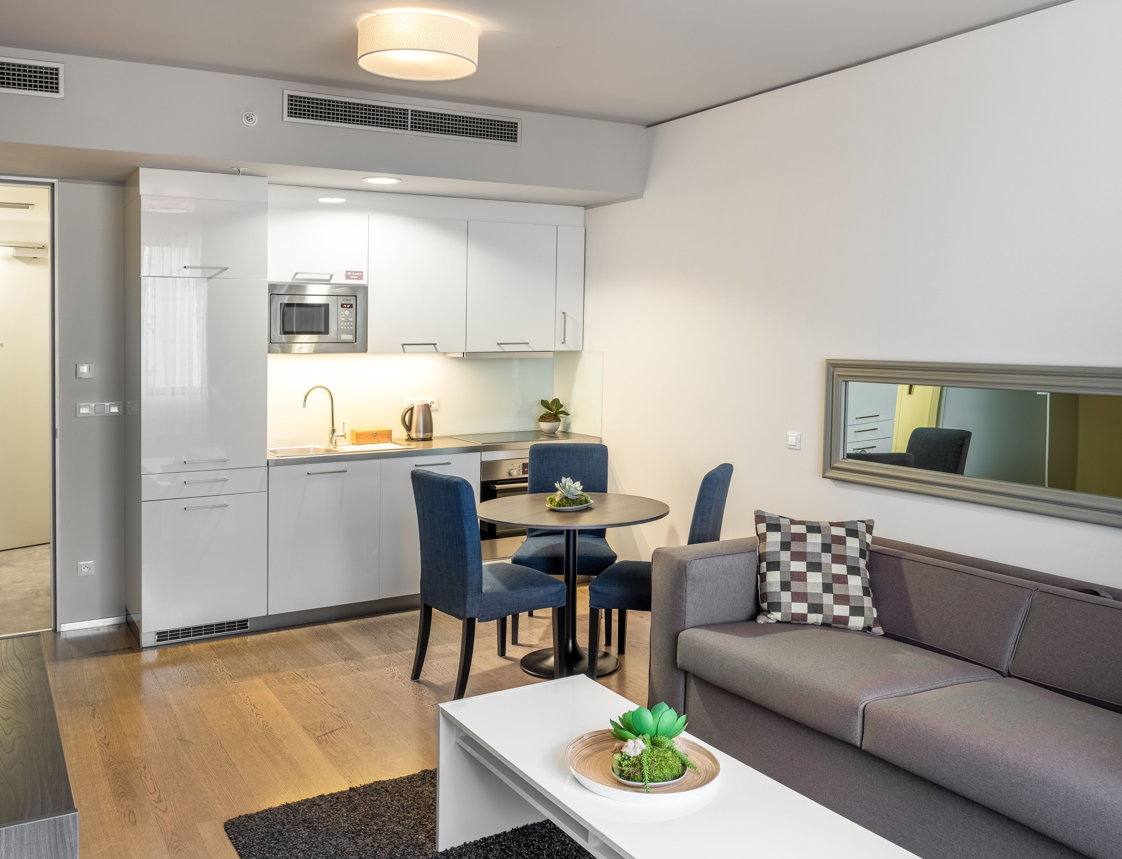 Un apartament modern amb cuineta, zona de menjador i saló.