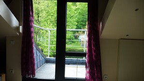 A room with a large window, a staircase, and a door. - Castle view apartment 1 (Großlohra)