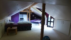 A compact attic bedroom with a bunk bed, a desk, and a chair. - Castle view apartment 1 (Großlohra)