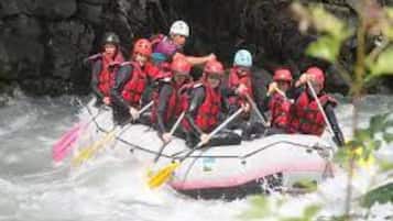 Un grupo de personas en balsas navegando un río.