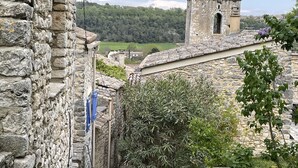 A stone building with a narrow alleyway, a small tower, and a view of a green valley. - Paradis de Provence / Leben wie Gott in Frankreich (Verfeuil)