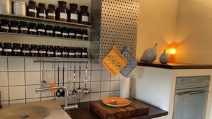A kitchen with a sink, stove, and shelves of jars. - Paradis de Provence / Leben wie Gott in Frankreich (Verfeuil)