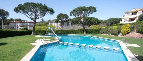 Relax by the serene pool surrounded by lush greenery and mature trees.