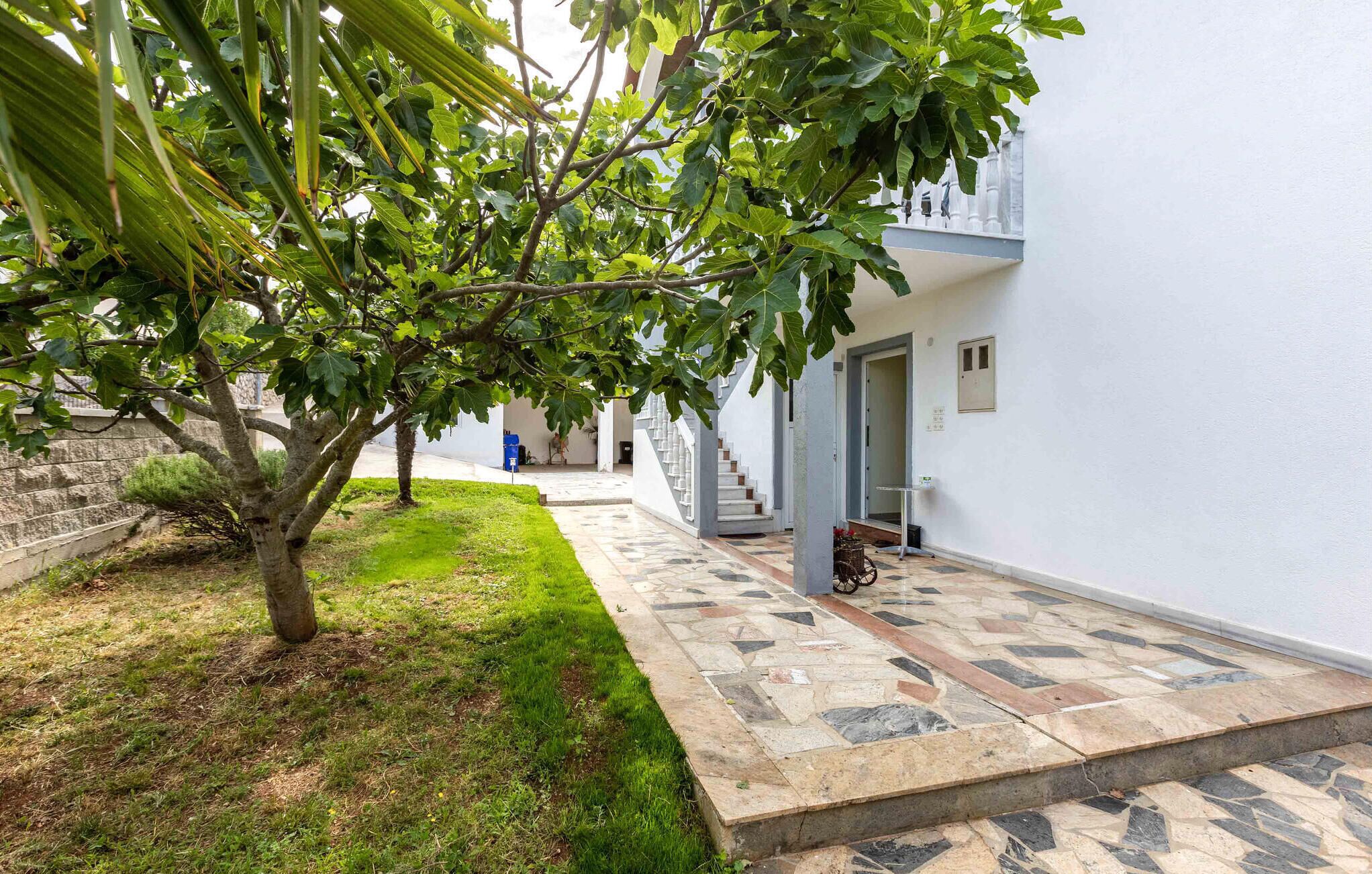 A courtyard with a tiled pathway leading to a staircase.