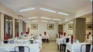A banquet hall with multiple tables set for dining, equipped with chairs and tables. - Hotel Andino (Encamp)